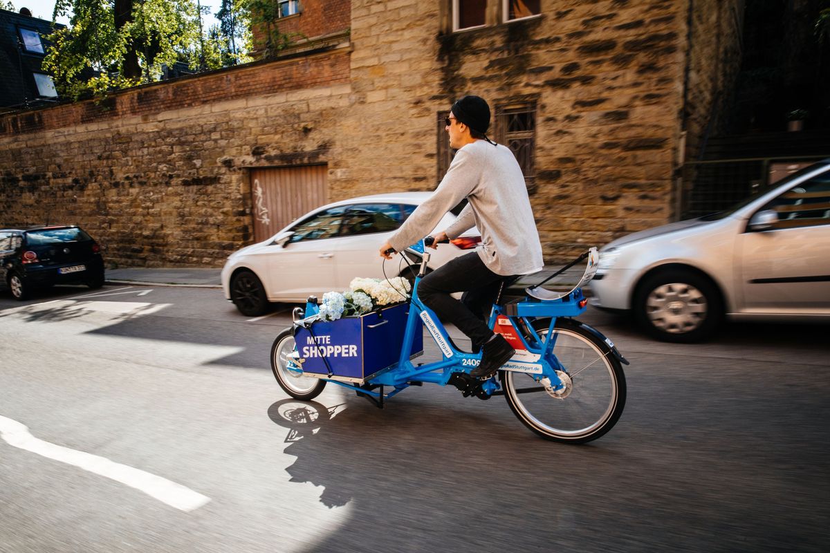 Mann transportiert Blumen mit RegioRadStuttgart Lastenpedelec auf der Straße