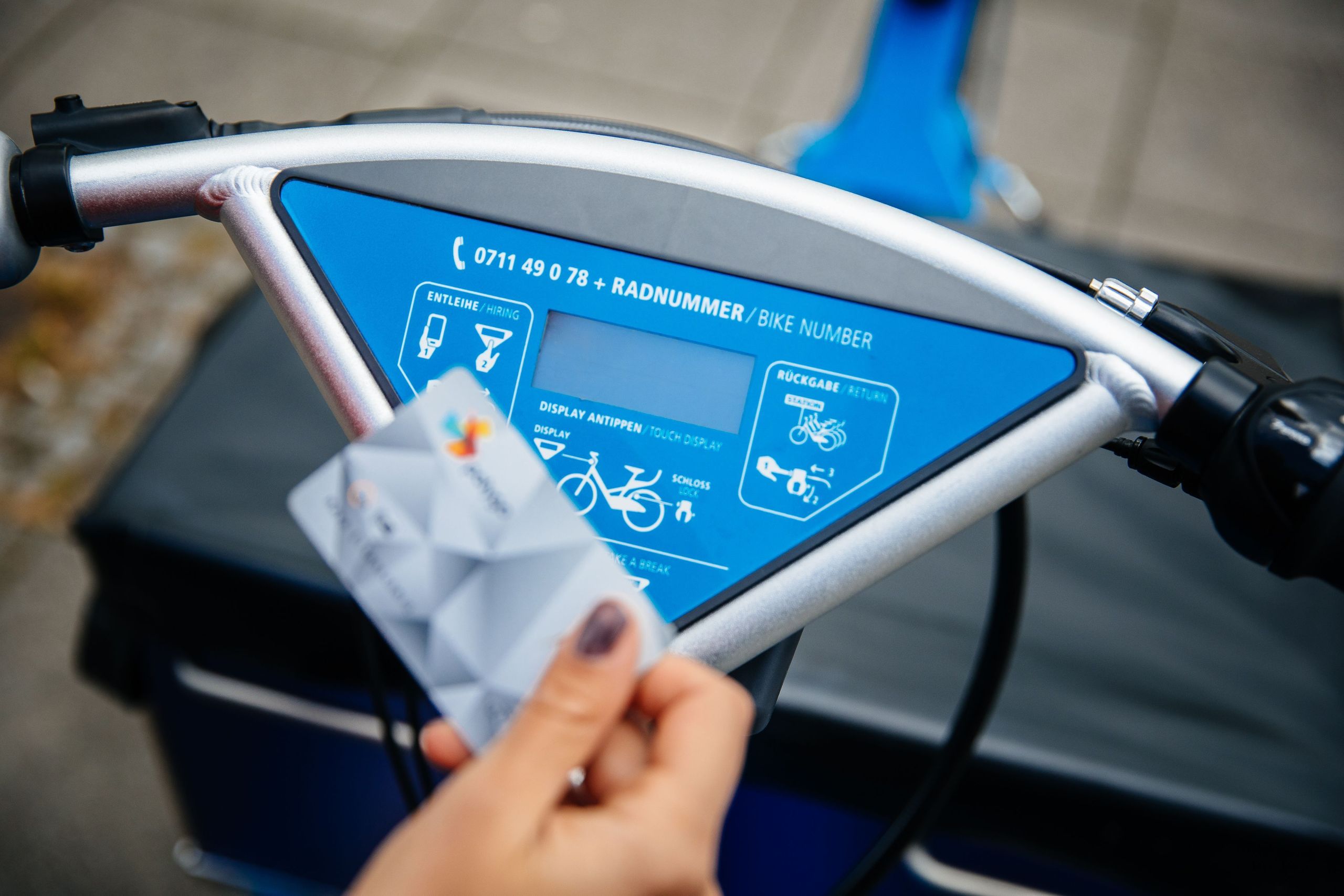 Frau hält ihre polygoCard vor Lenkerdisplay des RegioRadStuttgart Lastenpedelecs in der Hand