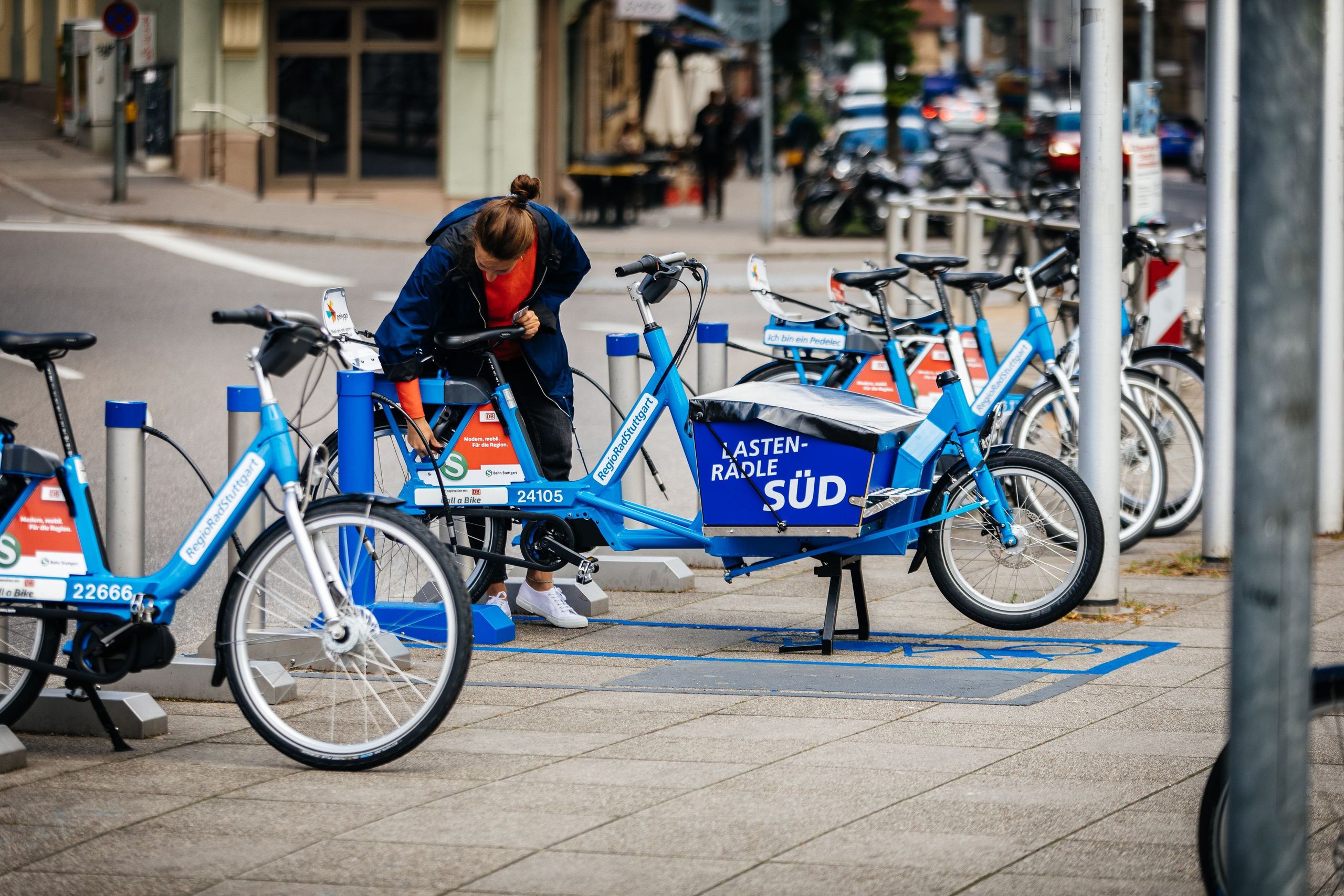 Frau schließt RegioRadStuttgart Lastenpedelec in der Stadt ab