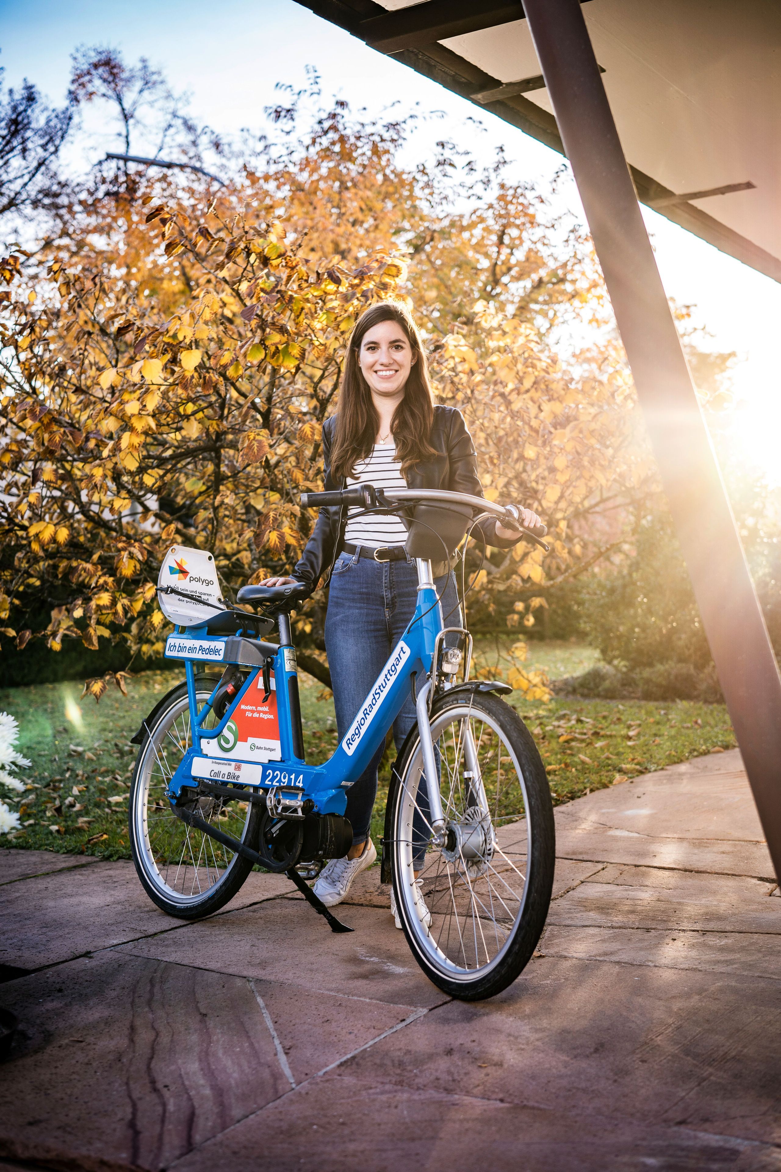 Happy woman standing next to RegioRadStuttgart Pedelic in nature